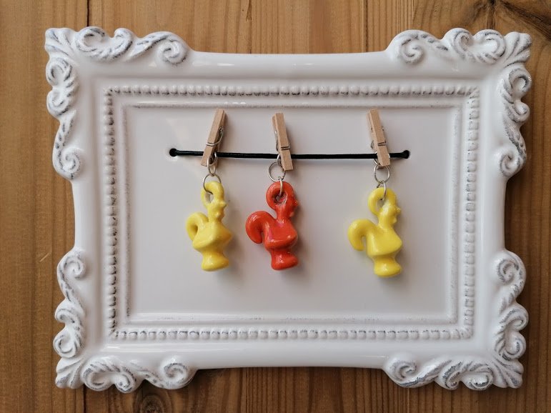 Frame with yellow, orange roosters on pegs