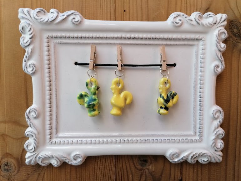 Frame with yellow, green roosters on pegs